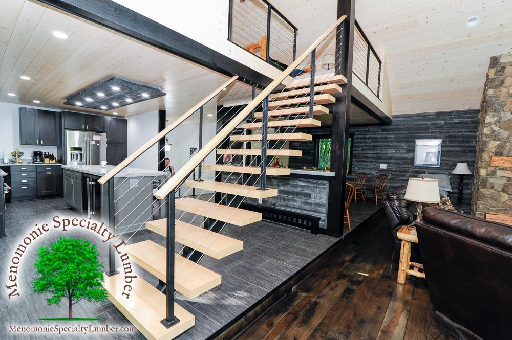 Custom made steel mono-stringer stairway with solid maple treads. Stainless steel cable hand rails with custom milled solid maple grab rail